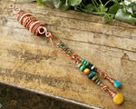 Yellow Jasper, Turquoise Dread Bead on a wood background.