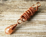Sunstone Copper Dread Bead on wood background.