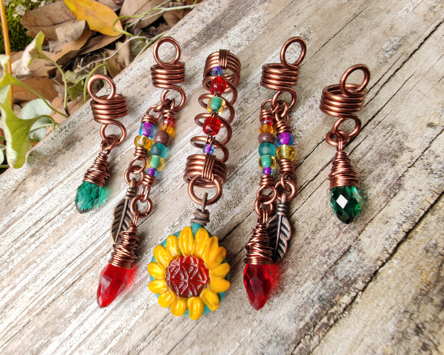 Set of 5 Sunflower Dread Beads on a wood background.