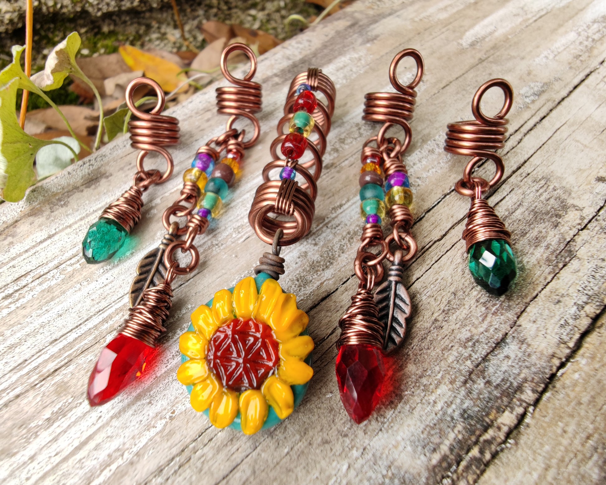 Set of 5 Sunflower Dread Beads on a wood background.