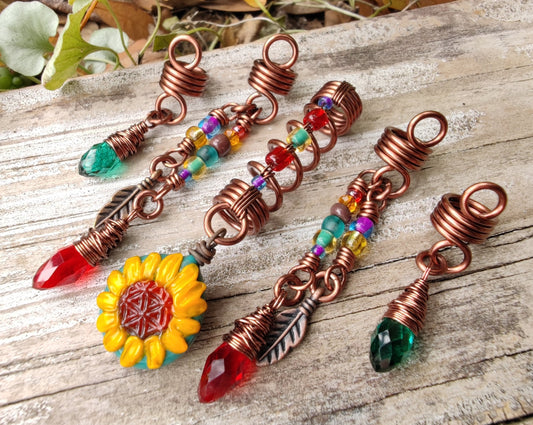 Set of 5 Sunflower Dread Beads on a wood background.