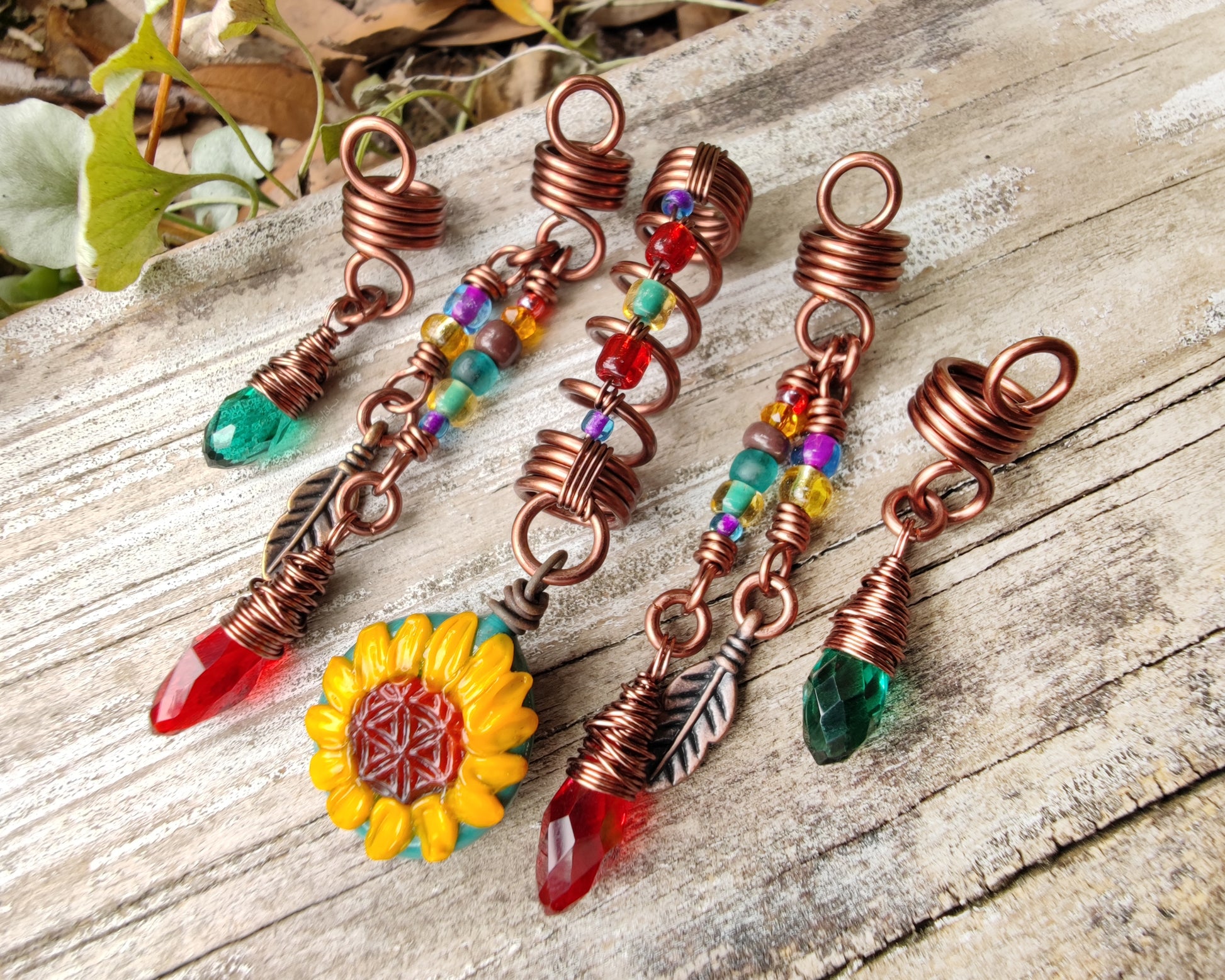 Set of 5 Sunflower Dread Beads on a wood background.