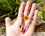 Set of 5 Sunflower Dread Beads in a hand to show scale.