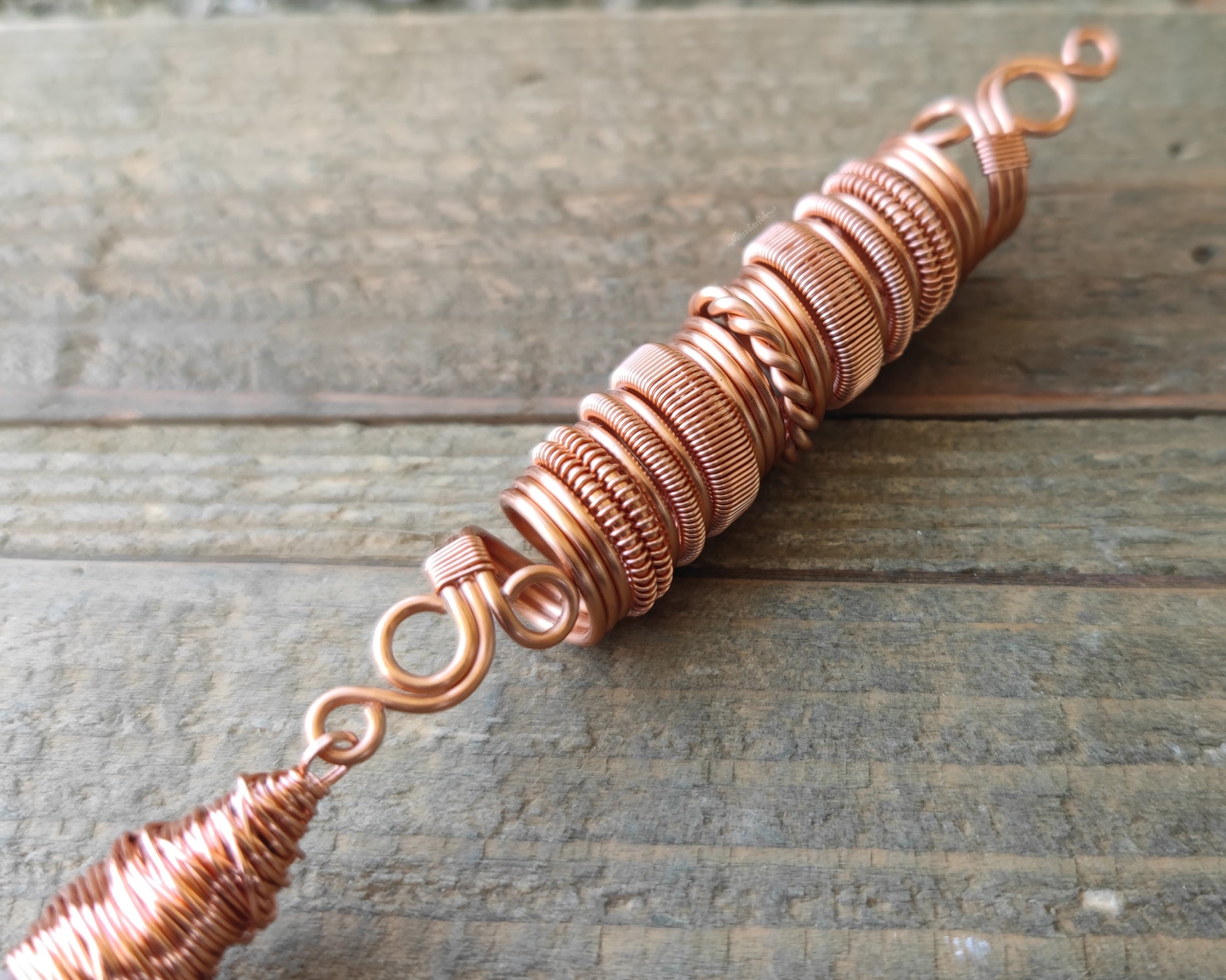 Iron quartz dread bead on wood background.