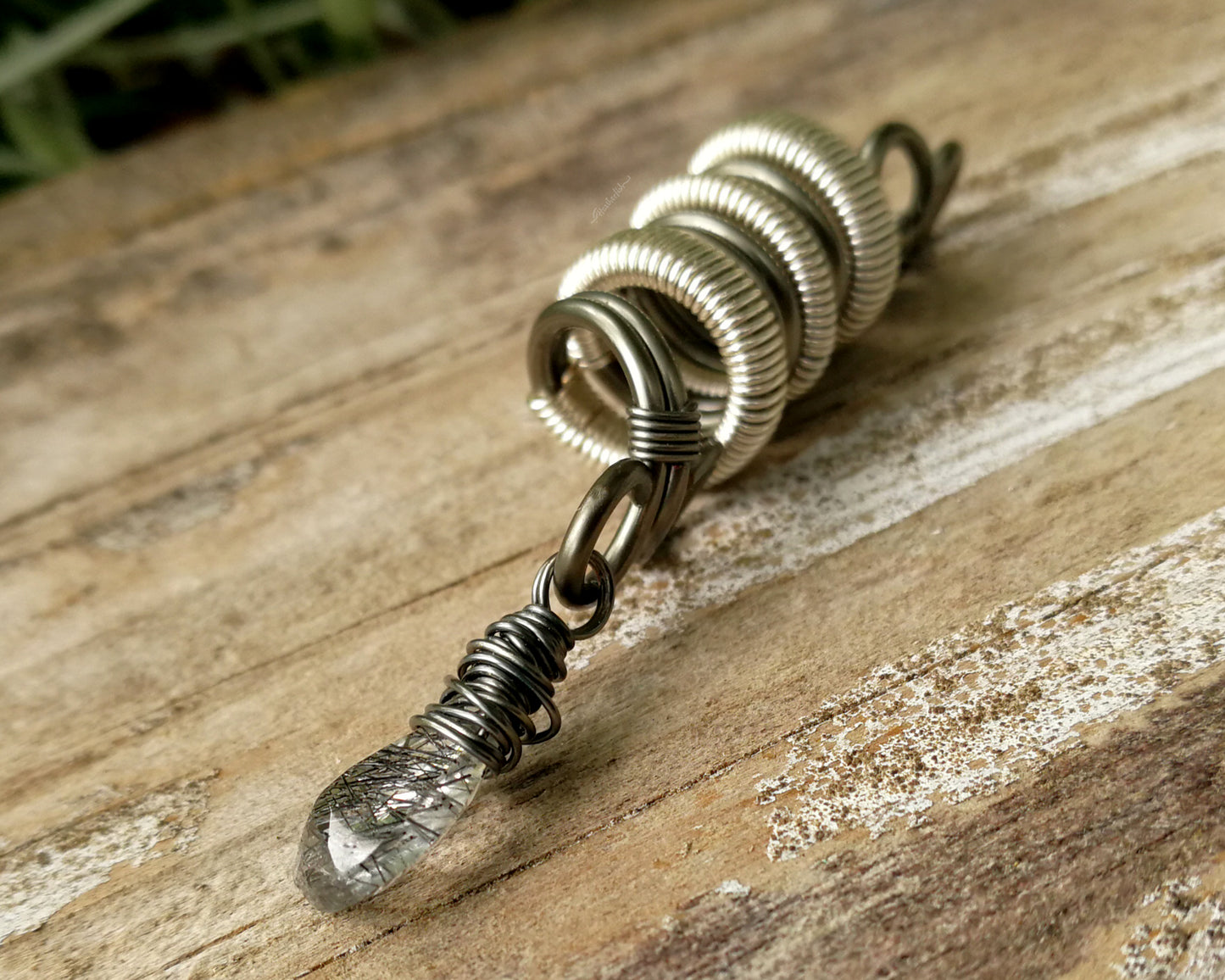 Two Tone Rutilated Quartz Dread Bead on wood background.