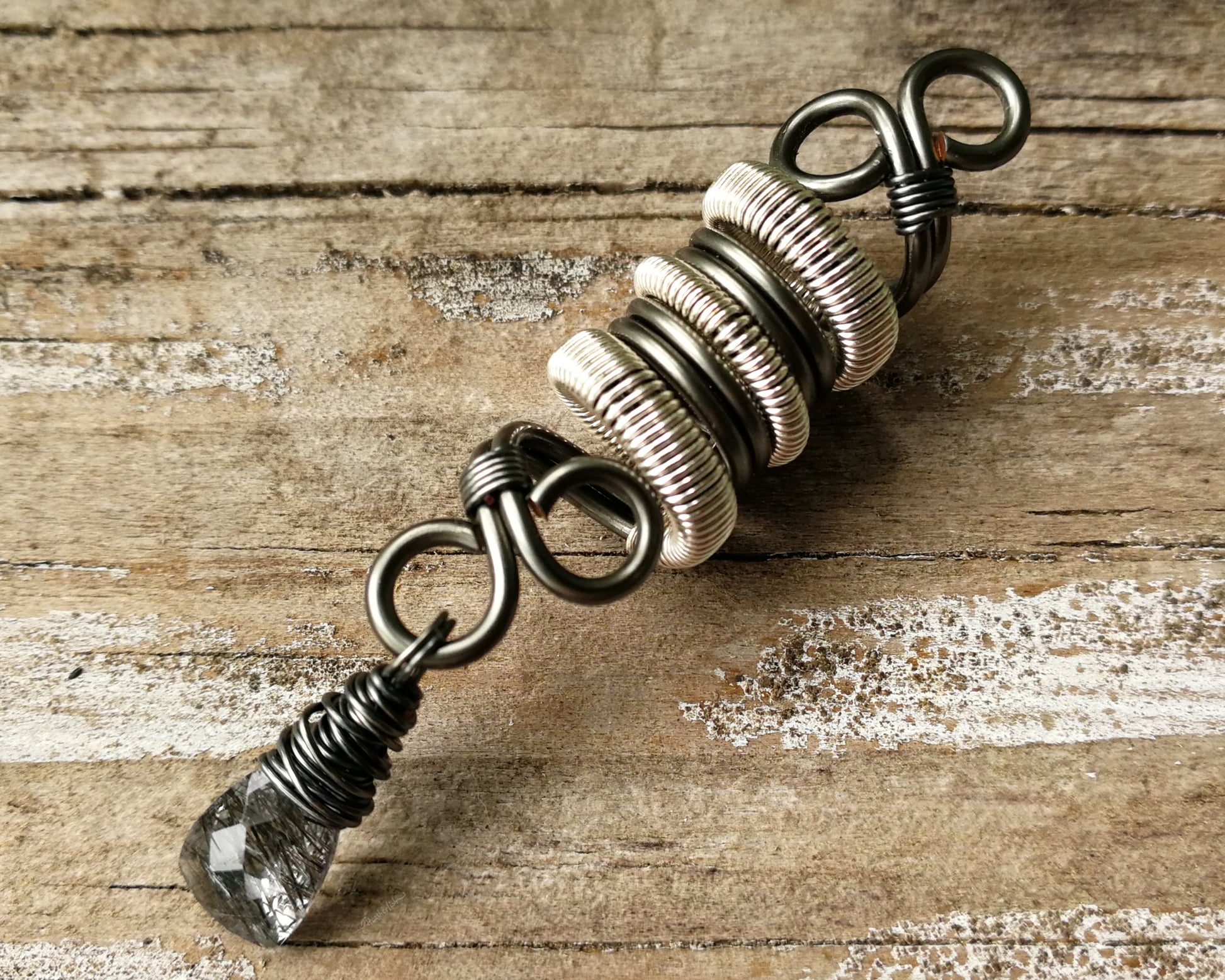 Two Tone Rutilated Quartz Dread Bead on wood background.
