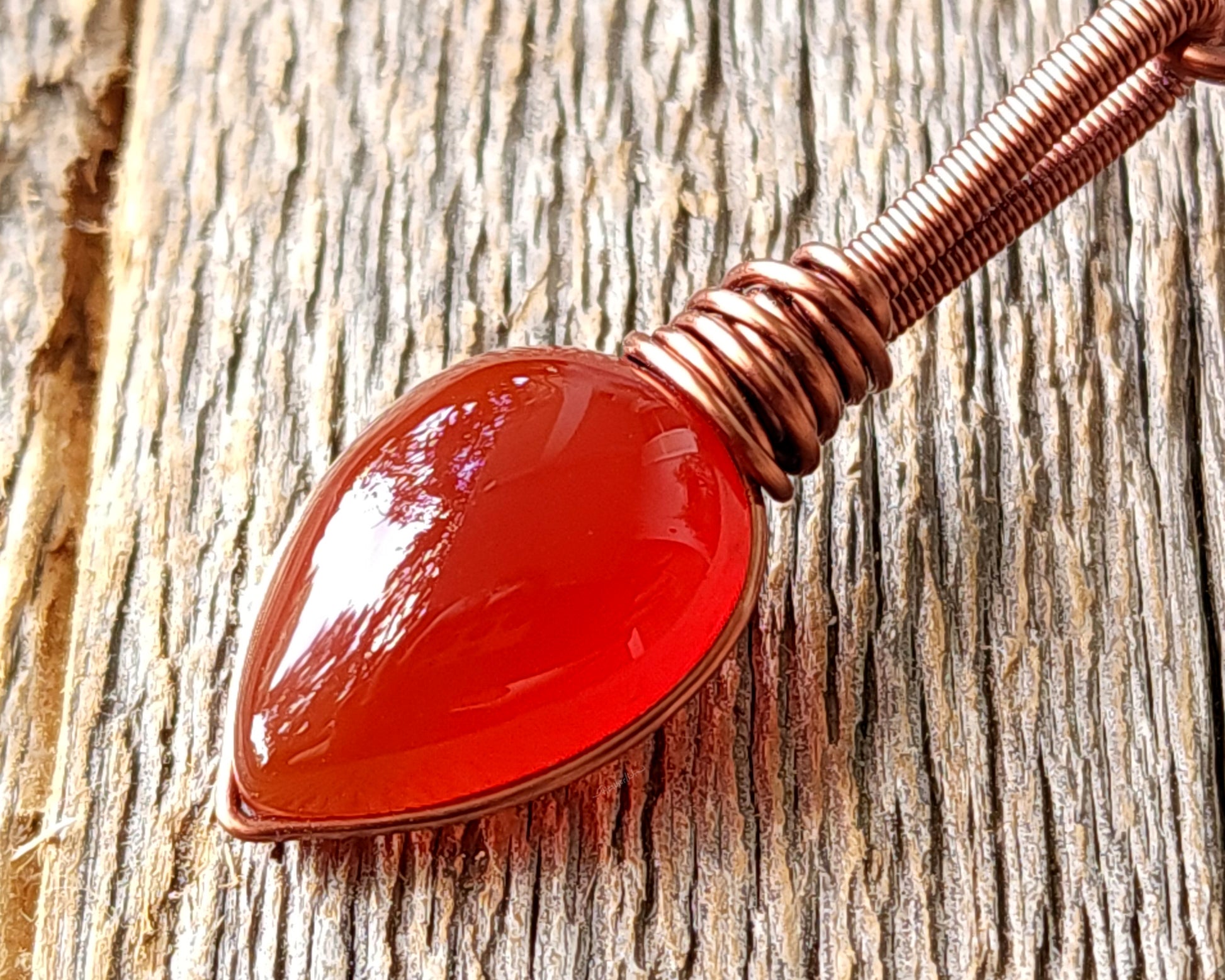 Red onyx fire dread bead on wood background.