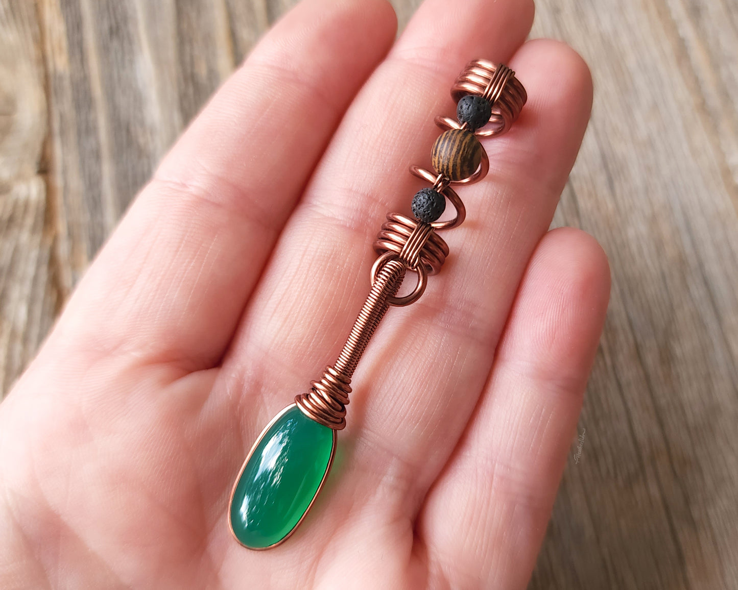 Green onyx earth dread bead held in hand to show scale.