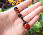Red Onyx Dread Bead held in hand to show scale.