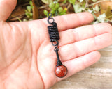 Banded Red Jasper Loc Bead held in hand to show scale.