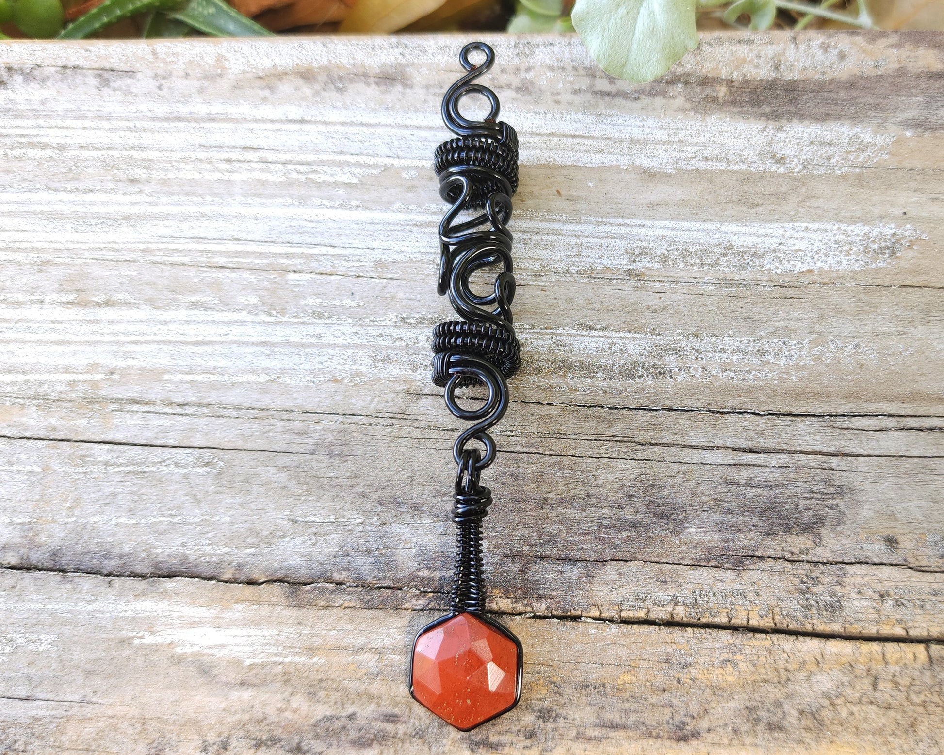 Jasper squiggle loc jewelry on wood background.
