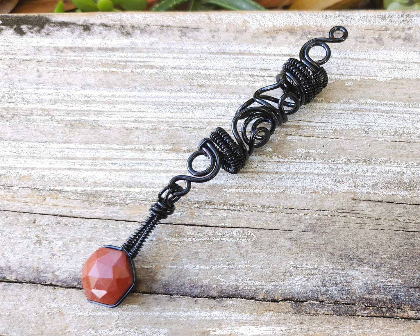 Jasper squiggle loc jewelry on wood background.