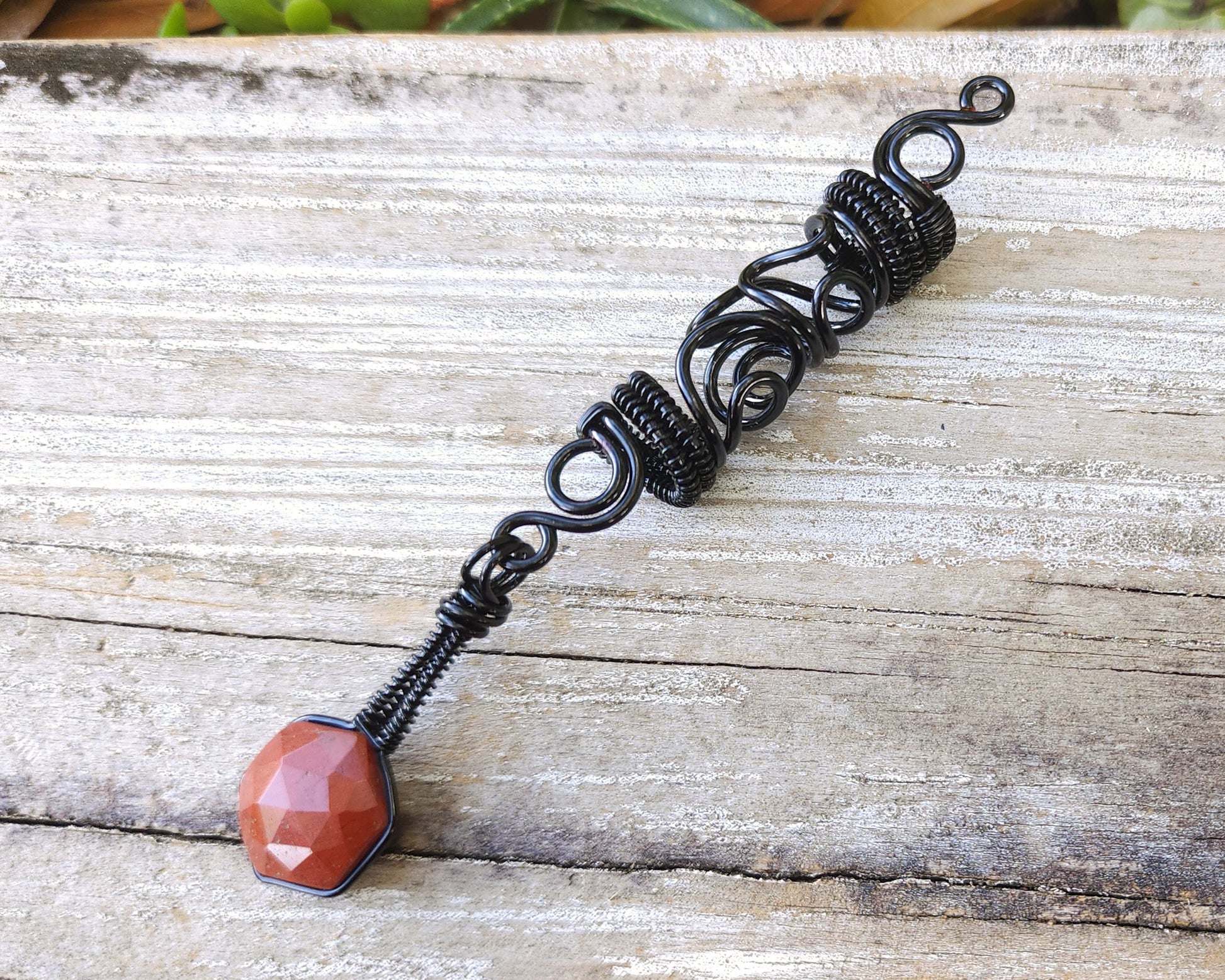 Jasper squiggle loc jewelry on wood background.