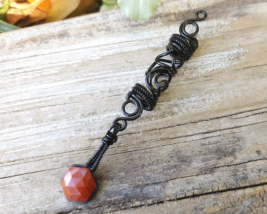 Jasper squiggle loc jewelry on wood background.