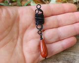 Red Jasper Tear Drop Loc Bead held in hand to show scale.