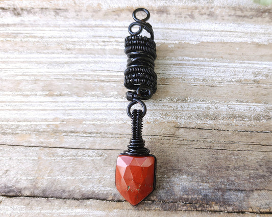 Fancy Rose Cut Red Jasper Loc Bead on a wood background.