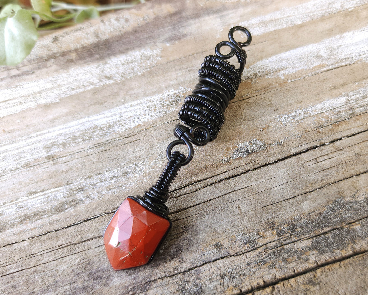 Fancy Rose Cut Red Jasper Loc Bead on a wood background.