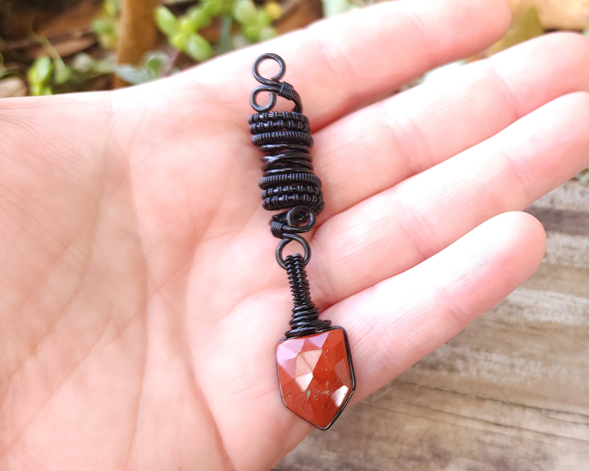 Fancy Rose Cut Red Jasper Loc Bead held in hand to show scale.