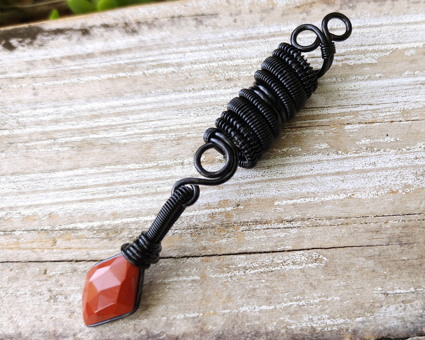 Red Jasper Loc Bead on a wood background.