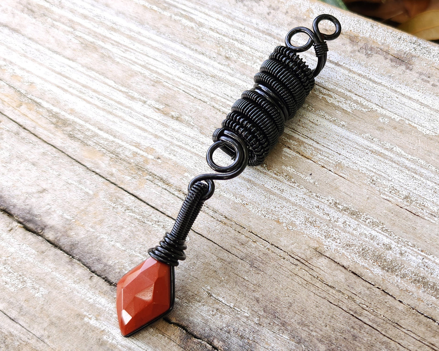 Red Jasper Loc Bead on a wood background.