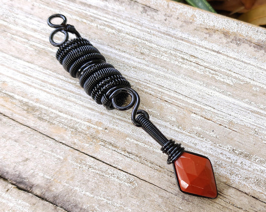 Red Jasper Loc Bead on a wood background.
