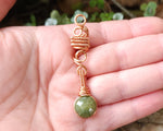 Green Vessonite Loc Bead held in hand to show scale.