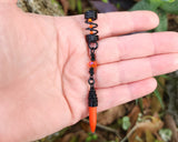 Orange Spike Loc Bead, Black Wire held in hand to show scale.