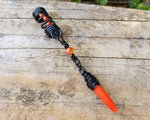 Orange Spike Loc Bead, Black Wire on wood background.