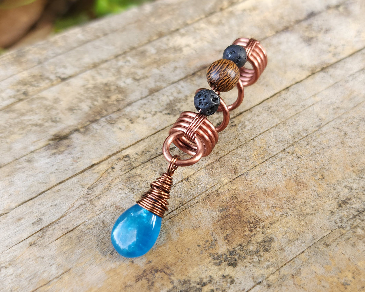 Neon Blue Apatite Loc Bead on a wood background