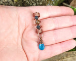 Neon Blue Apatite Loc Bead held in hand to show scale