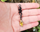 Step Cut Bumble Bee Jasper Loc Bead held in hand to show scale.