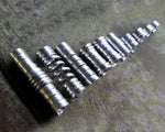 Set of 10 stylized aluminum dread beads laid out in a row