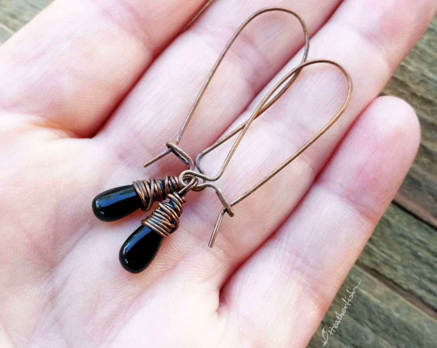 A pair of Black Onyx Earrings in hand. 