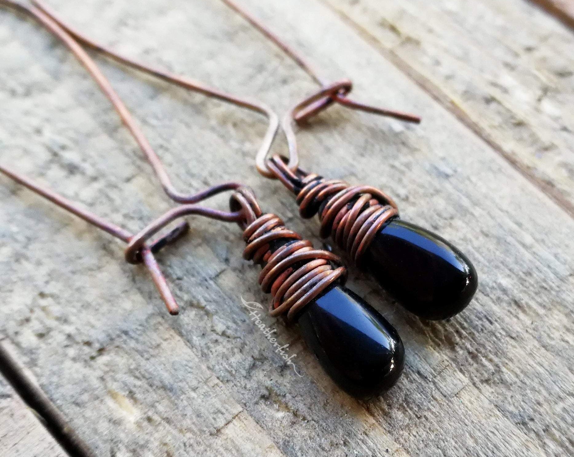 A close up of  Black Onyx Earrings on a wooden background.