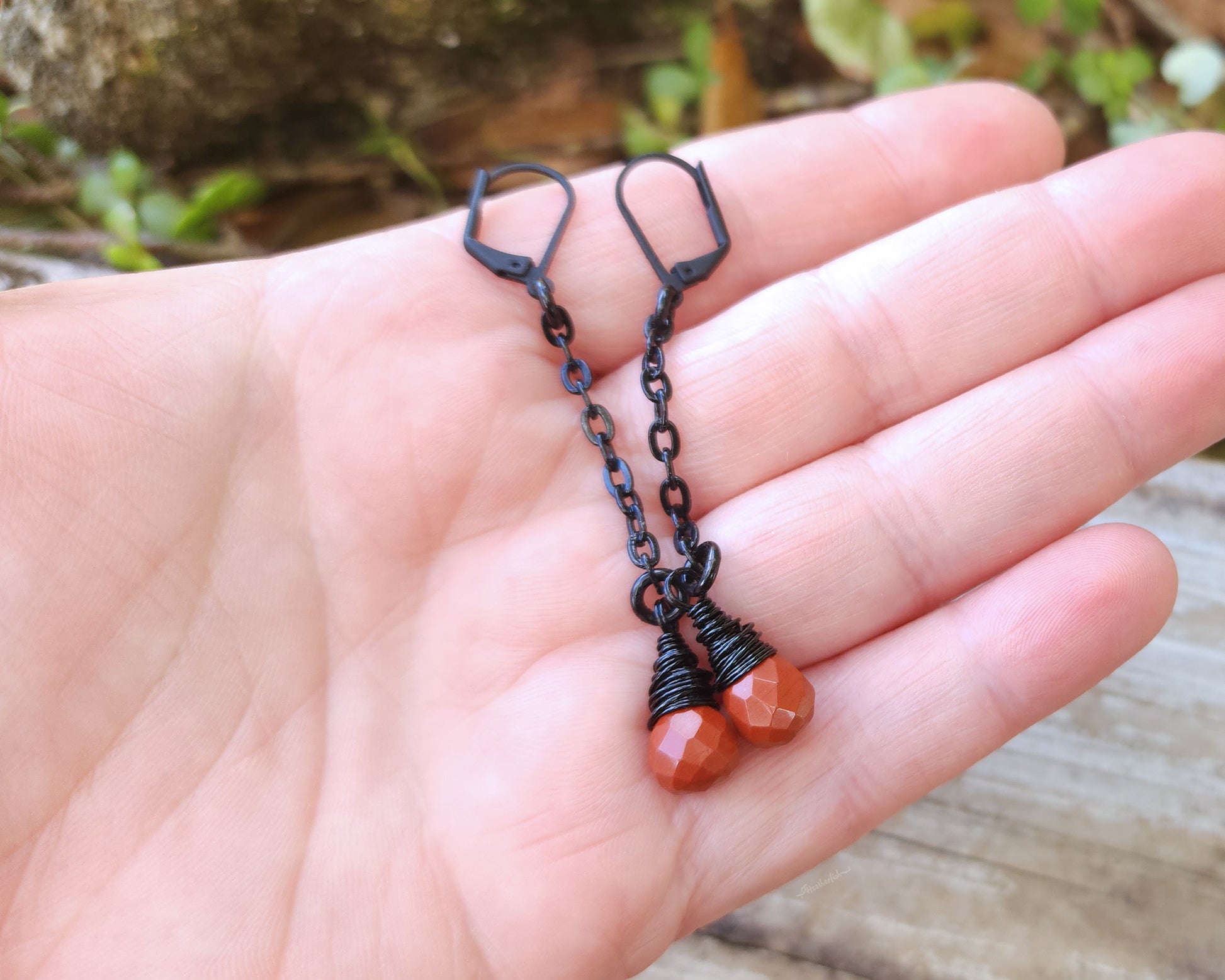 Red Jasper Earrings with black findings held in hand to show scale.