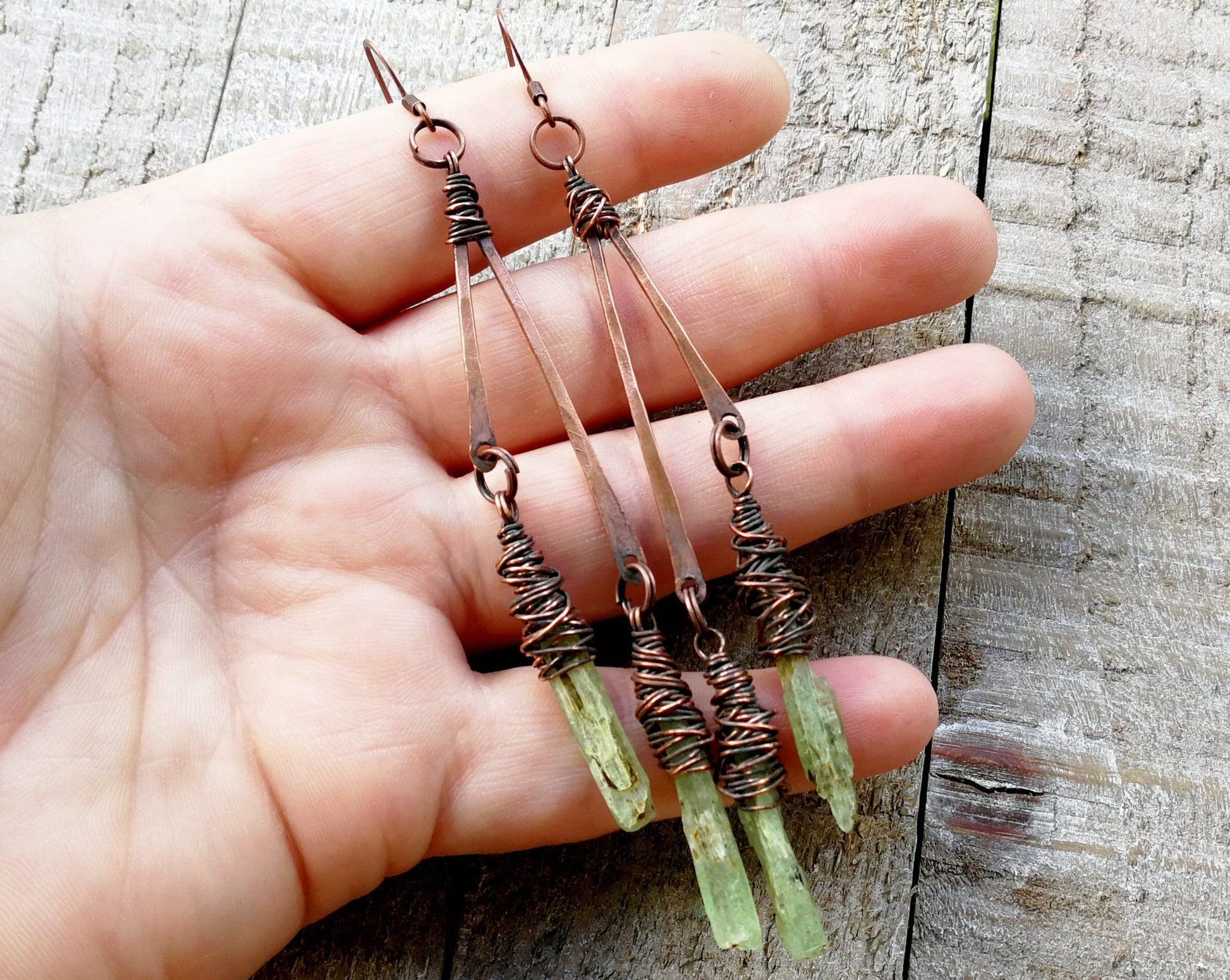 A hand view of Boho Green Kyanite Earrings