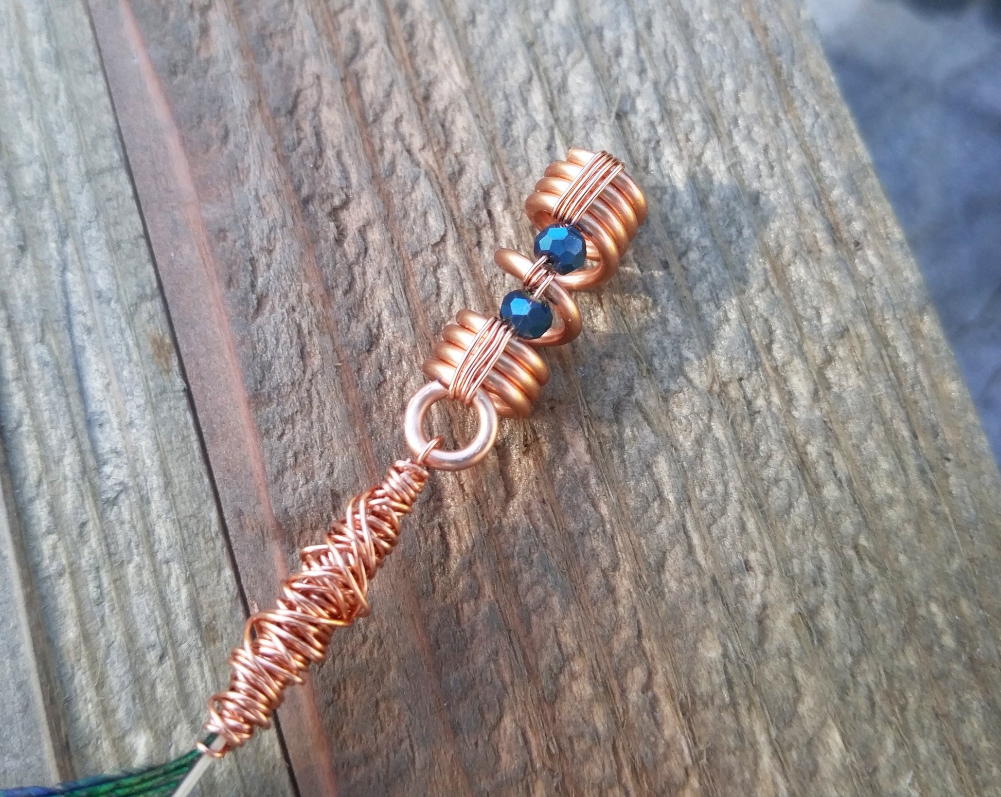 A close up of the coil portion of the peacock blade dread bead.