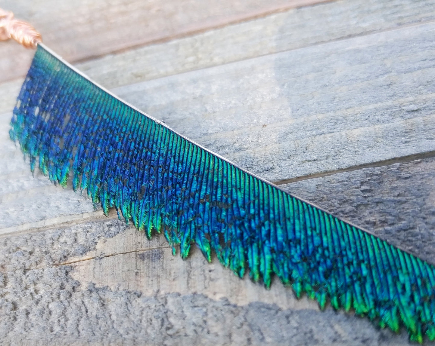 A close up shot of the feather portion of the peacock blade dread bead.