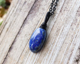 Lapis Lazuli Necklace, Black Chain on wood background.