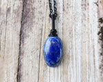 Lapis Lazuli Necklace, Black Chain on wood background.