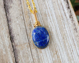 Lapis Lazuli Necklace, Gold Tone on a wood background.