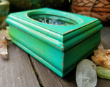 Sea green crystal box on a wood display background.