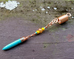 A side view of a Turquoise Spike Dread Bead.