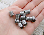 A top view of Oxidized Aluminum Dread Beads Set of 10 in hand.