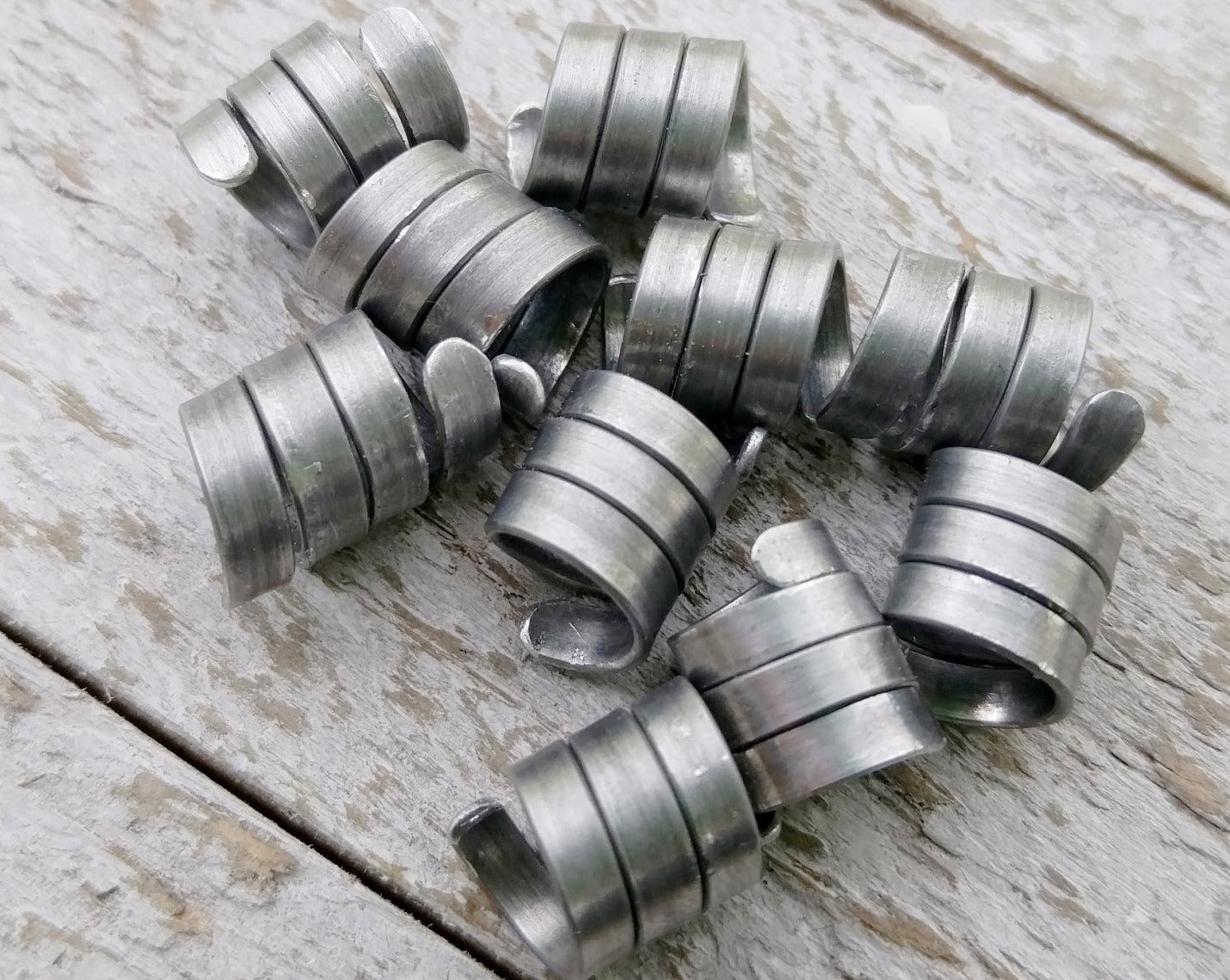 A top view of Oxidized Aluminum Dread Beads Set of 10 on a wooden background.