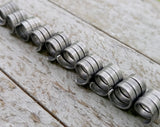 A side view of Oxidized Aluminum Dread Beads Set of 10 in a row. 