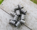 A top view of Oxidized Aluminum Dread Beads Set of 10 on a wooden background.