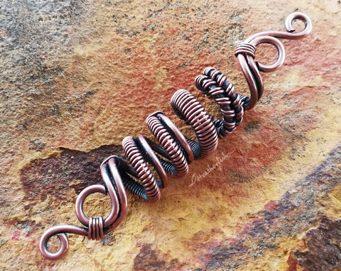 A close up view of a Oxidized Copper Loc Bead.