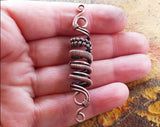 A top view of a Oxidized Copper Loc Bead in hand.