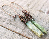 A close up view of Green Kyanite Earrings wrapped in Oxidized Copper.